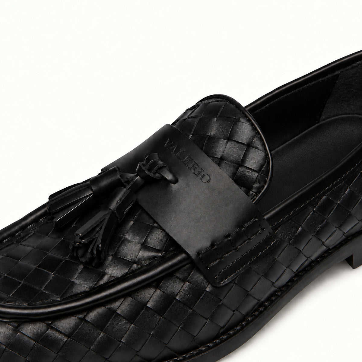 VALERIO Positano Loafer Uomo in Vitello Intrecciato Nero con Nappine – dettaglio delle nappine e del logo VALERIO